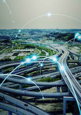 Raccordo stradale e città visti dall'alto con connessioni luminose_NTT DATA 5G Enabling Fabric