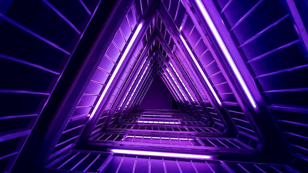 Tunnel triangolare di tubi luminosi viola_Data Protection NTT DATA: innovazione by design e by default