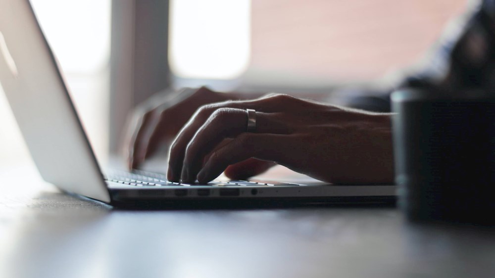 mani di una persona mentre lavora al pc